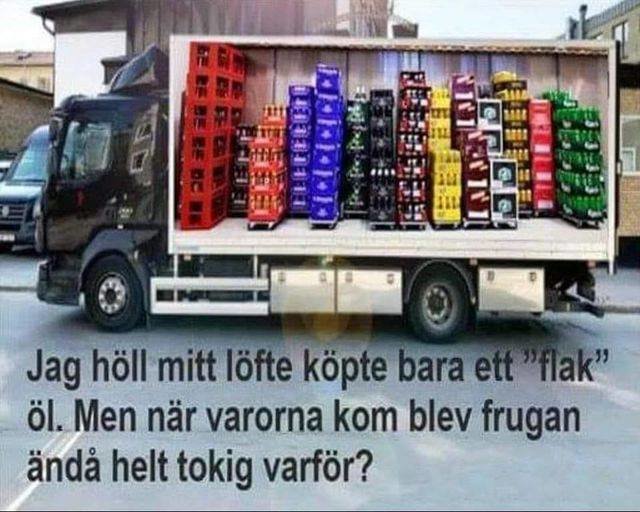 Lastbil lastad med stora ölbackar staplade för att likna en ölflaska med textskämt.