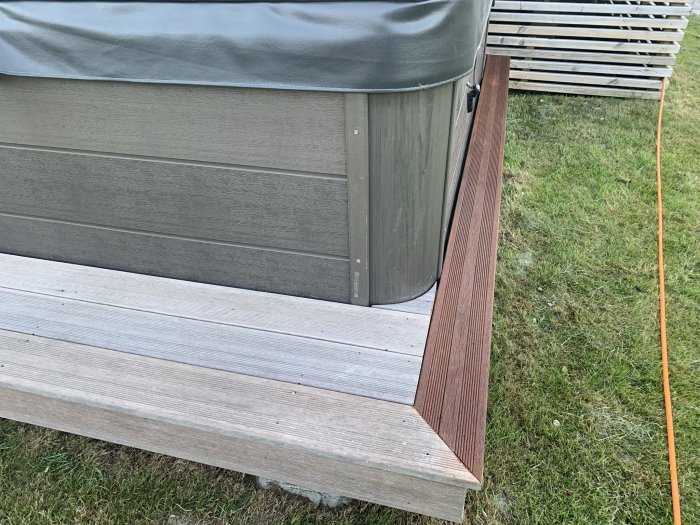 Trallbräda och loungebord behandlade med burmateak visas bredvid varandra, illustrerar olika nyanser av brun.