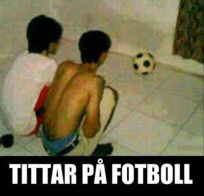 Två personer sitter på golvet och tittar mot en fotboll, texten "TITTAR PÅ FOTBOLL".