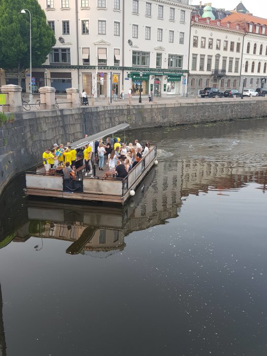 Folkfylld flotte på vattnet vid Kungsportsbron i Göteborg under kvällstid.