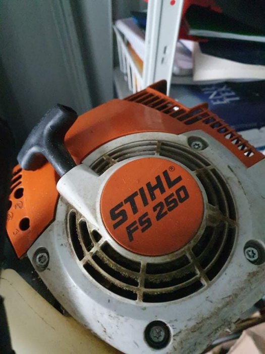 Röjsåg av märket Stihl FS 250 med fokus på startmekanismen och logotyp.