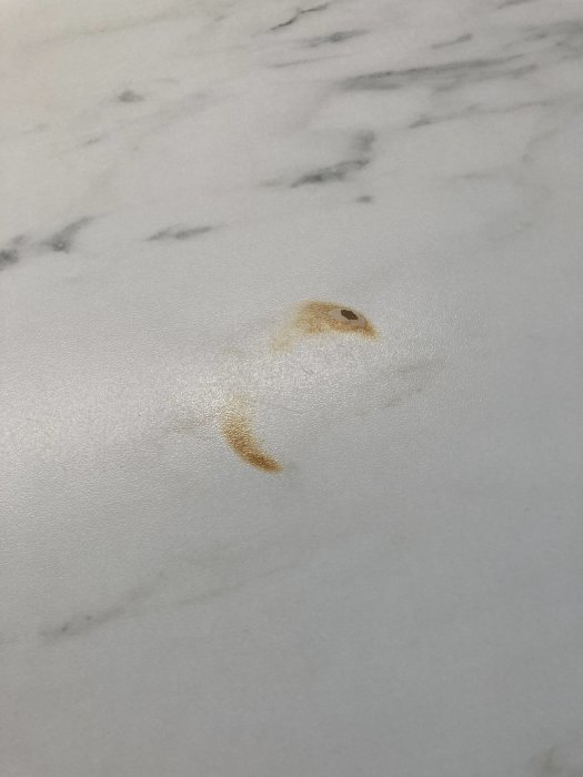 Brännmärke på vit och grå marmorliknande laminatbänkskiva från IKEA.