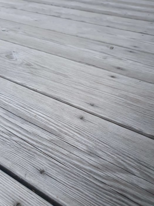 Vinklad närbild av en grå trall med skruvar nedsänkta under ytan, inga stickor synliga efter 8 år.