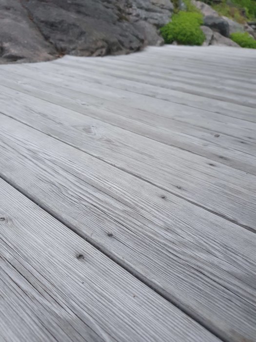 Trallgolv utomhus med skruvar neddragna så att träet svällt över dem.