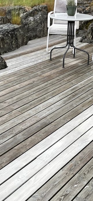 Blöt trall med tre närmaste brädor målade med fönsterfärg och resten behandlade med trädäcksolja och tjära.