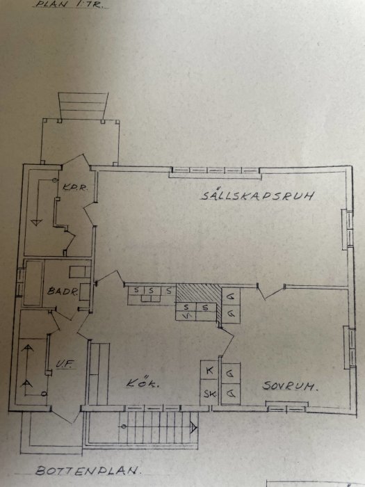 Handritad byggplan med olika rum benämnda, såsom kök och sovrum, och en noterad öppning i området K.L.K.