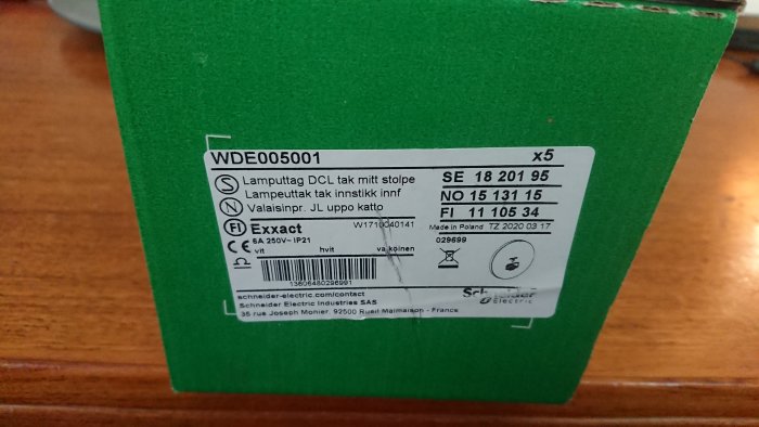 Etikett på en grön förpackning för fem DCL-uttag till infällda dosor med mittstolpe.
