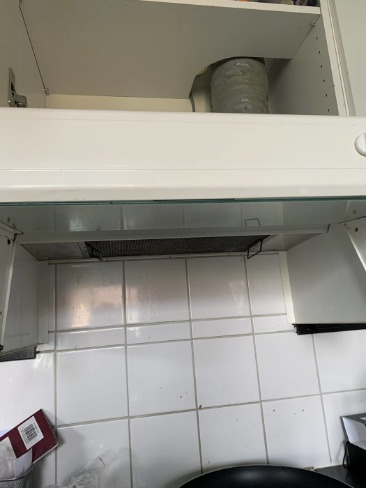 Köksskåp ovanför fläktkåpa utan synliga skruvar eller fästelement.