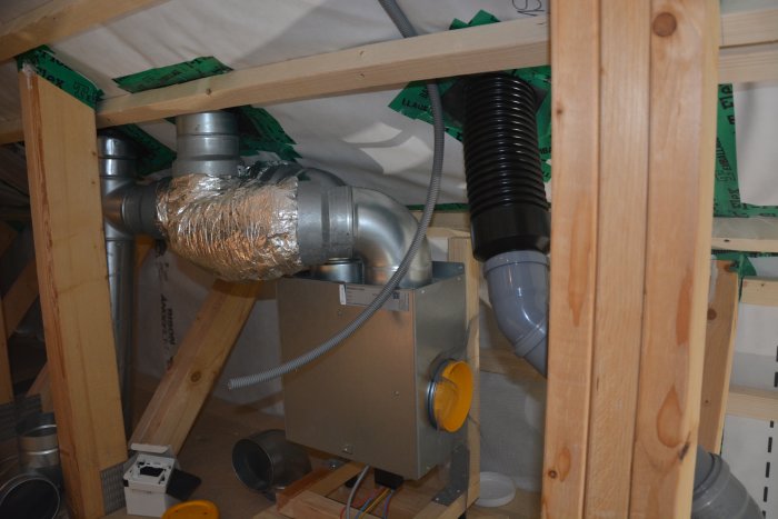 Ventilationssystem och avloppsrör installerade under konstruktion i ett hem.