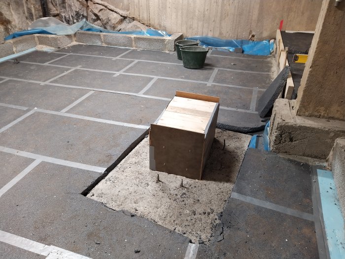 Nybetongade markplattor och trälåda för markarbeten vid byggprojekt.