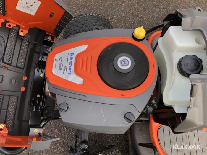 Översikt på en Husqvarna 238 gräsklippare med synlig Kinamotor och delar av klippaggregatet.