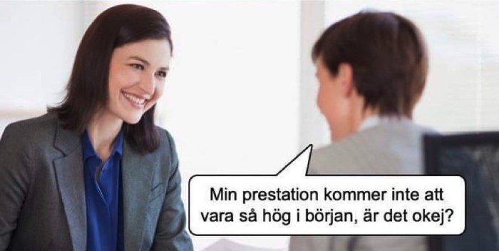 Två personer i affärskläder sitter mitt emot varandra, en kvinna ler med pratbubbla om prestation.