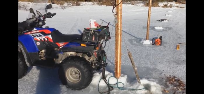 ATV med vinsch används för att installera pålar i isen för en brygga.