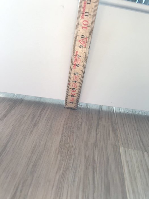 Måttband visar 10 mm avvikelse vid golv och dörrfoder.