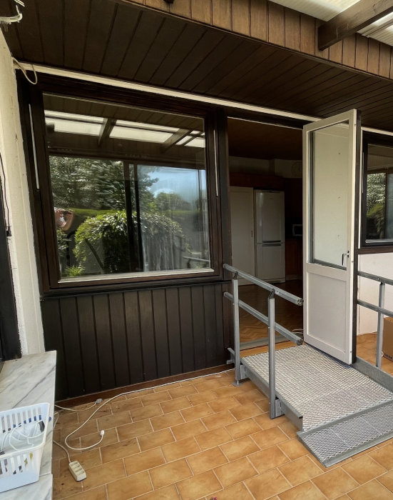 Uterum med öppen dörr, fönster och träklädd vägg, avsedd för installation av parfönsterdörr.