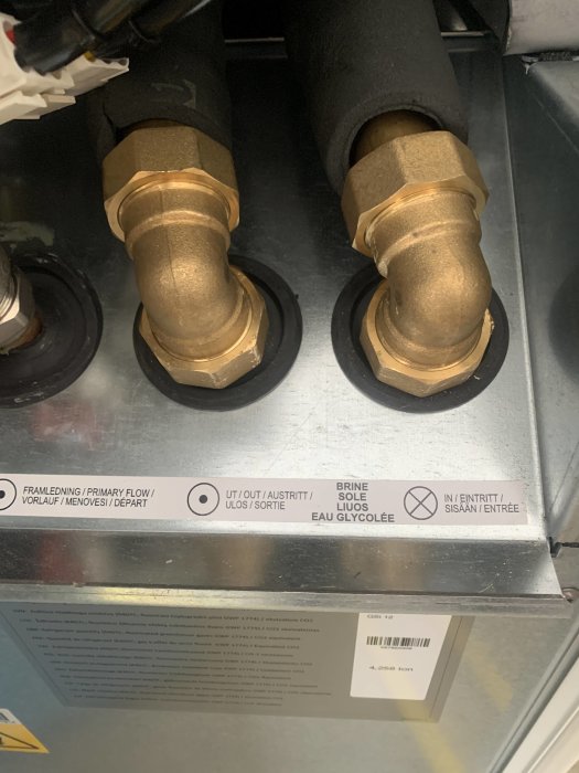 Värmepumpanslutningar markerade med 'Brine UT' till vänster och 'Brine IN' till höger med förvirrande markeringar.