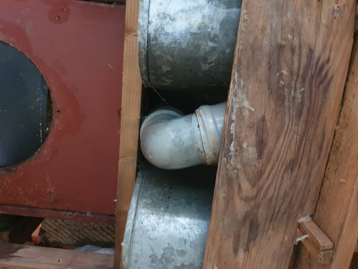 Rostig och gammal metalltrumma i ett hus, troligen för ventilation, behov av utbyte före renovering.