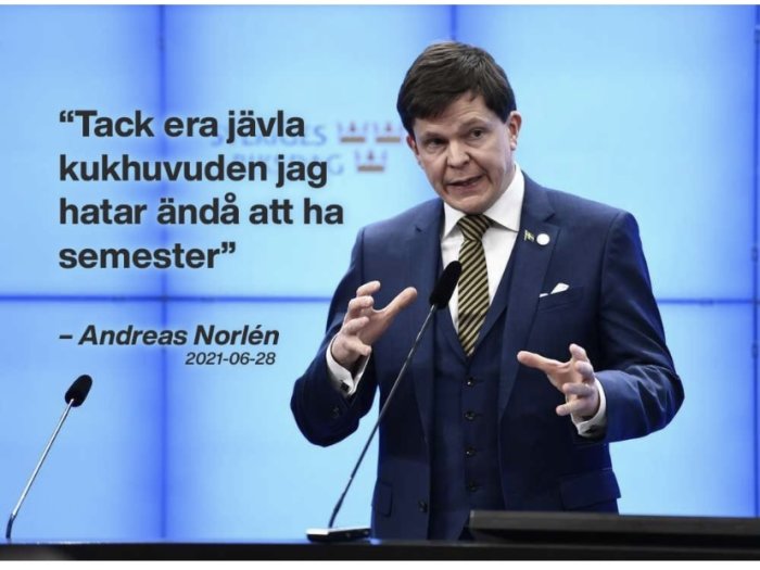 Person som gestikulerar vid ett podium med en påstått citat av Andreas Norlén på bakgrundsskärm.