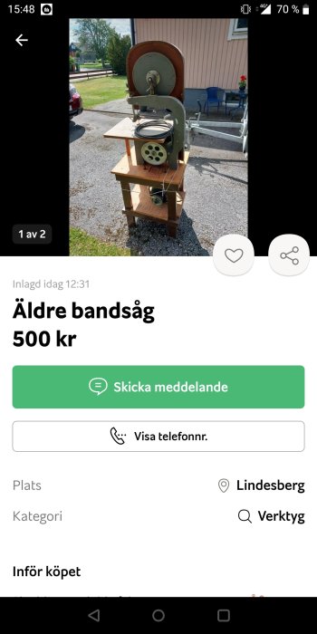 Äldre vertikal bandsåg utsatt till försäljning utomhus i dagsljus.