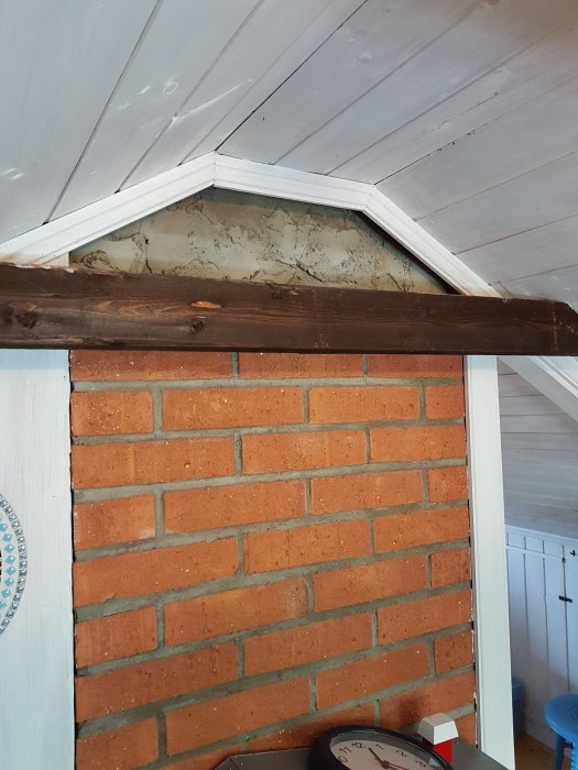 Frilagd murstock med oavslutat hålrum nära taket och tegelvägg nedtill.