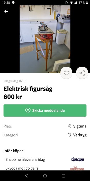 Röd elektrisk figursåg placerad på en träbock i ett välorganiserat hantverksrum.