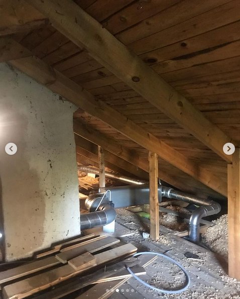 Installation av frånluftsventilation på vinden med synliga rör och isoleringsmaterial.