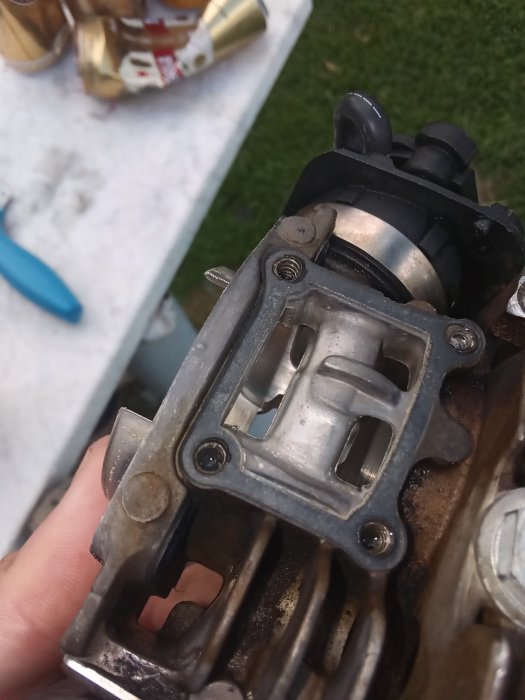 Hand håller öppet cylindern på en Jonsered 2152a motorsåg med synlig otät spolkanal.