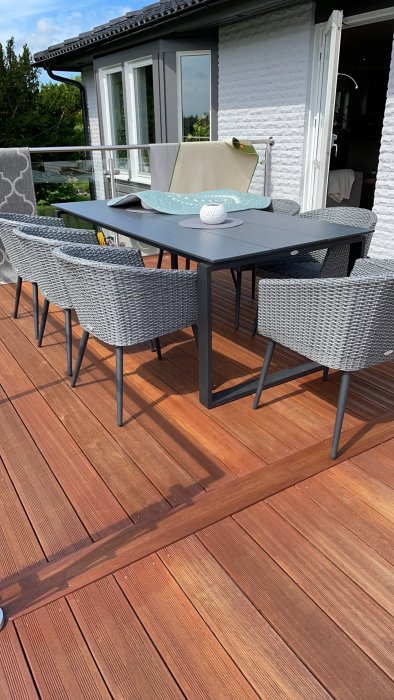 Nyrenoverad trädäck med utemöbler, redo för barfota avkoppling utan stickor.