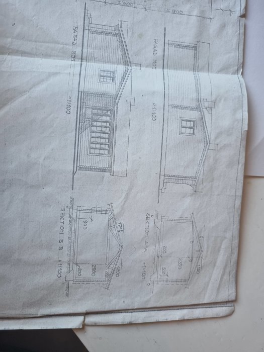 Arkitektritning av ett timmerhus med markerade väggar för möjlig öppning och planerade fönsterplatser.