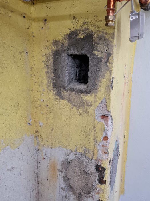 Gamla rökkanalen i pannrum med gult skalad färg och synlig murbruk, redo för renovering.