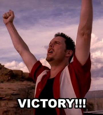 Man höjer armarna i luften och firar en seger, med texten "VICTORY!!!" tryckt över bilden.