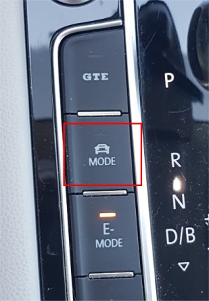 Närbild på bilens körlägesväljare med en knapp markerad som 'MODE'.