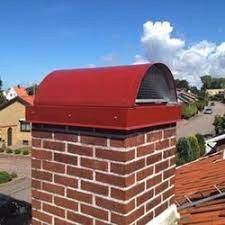 Röd skorstenshuv installerad på tegelskorsten mot blå himmel för att förhindra fågelbon.