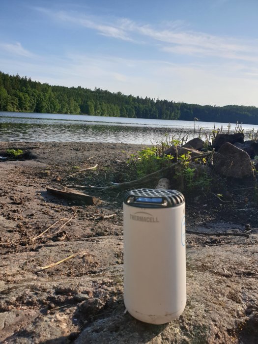 Thermacell myggskydd på marken vid en sjö i skogen under skogstältning.