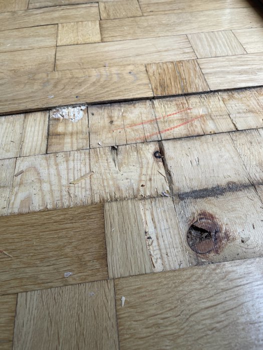 Parkettgolv med skador och synlig underlag där en stav tagits bort, visar 5mm tjocka stavar.