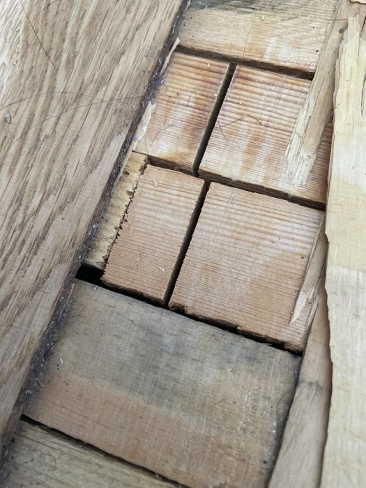 Närbild på golvplankor med synlig skarv och olika tränyanser.