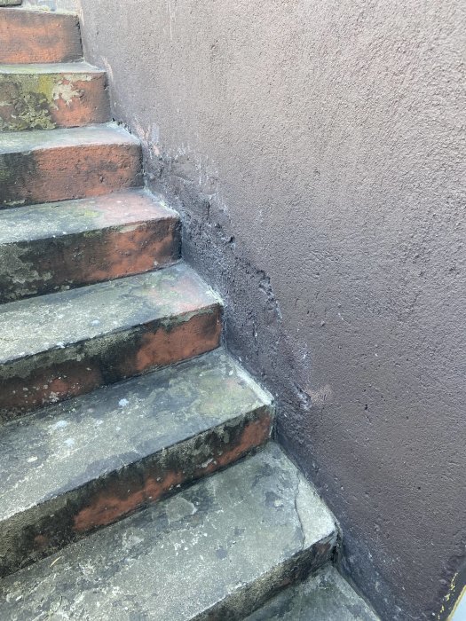 Reparation av betongtrappa, med nylagt bruk i sprickor och hål vid väggmötet.