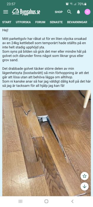 Skadat parkettgolv med ett synligt hål och underliggande material som liknar grus, orsakat av en fallen kettlebell.