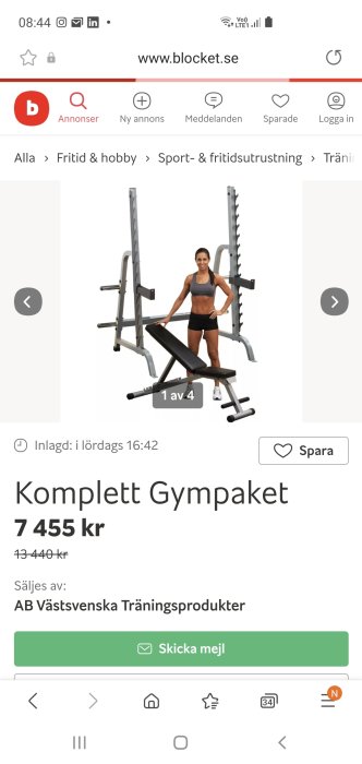 Person stående bredvid stort gymrack med ställningar och vikter, ironisk posering.