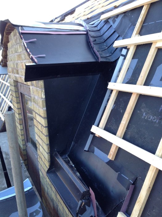 Delvis rivet tak med synlig takstol samt vägg före renovering.