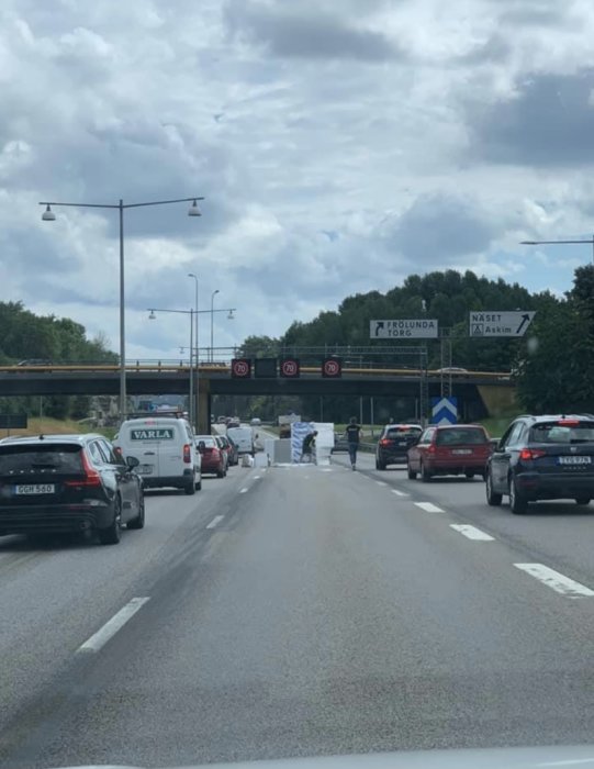 Trafikstockning på motorväg med vägskyltar till Frölunda Torg och Näset.