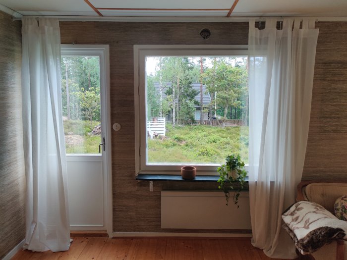 Inredningsrum med fönster och gardiner, röda och blå markeringar på väggen där installation planeras.