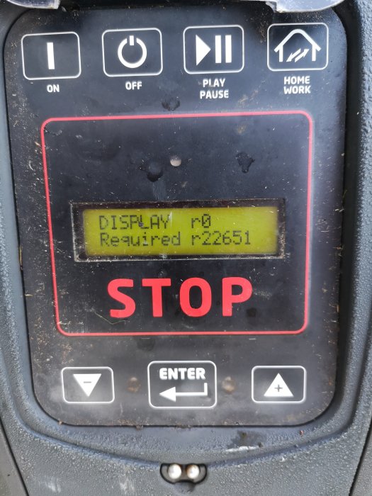 Smutsig display på en robotgräsklippare visar felmeddelande "Display r0 Required r 22651" och ordet "STOP".