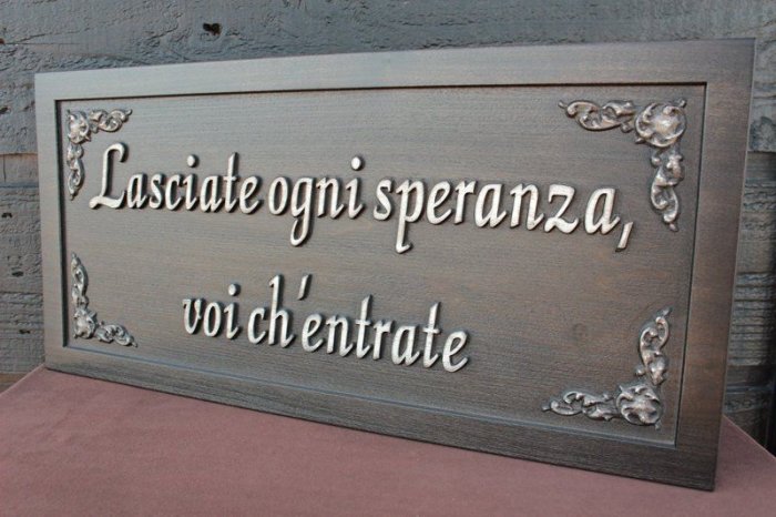 Skylt med italienska citatet "Lasciate ogni speranza, voi ch'entrate" med dekorativa detaljer.