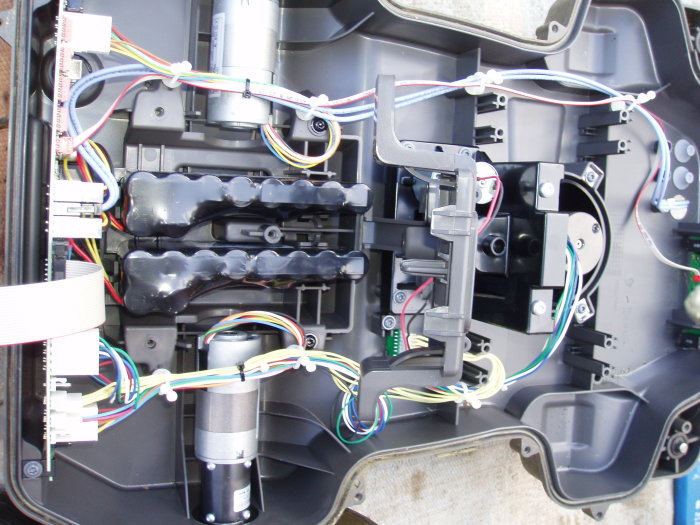 Interiör av Husqvarna Automower 330x med gamla batterier och elektroniska komponenter.