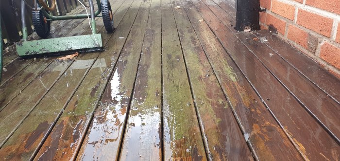 Otvättad balkong i trä före målning med synlig smuts och mossa.
