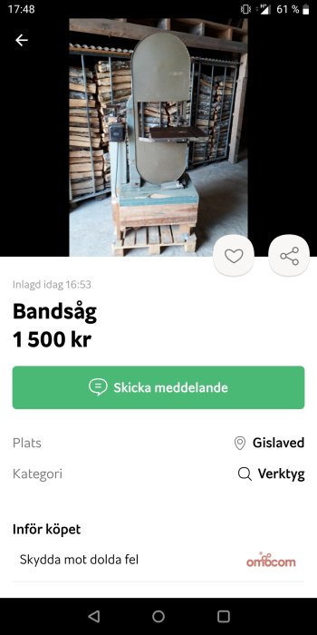 Begagnad bandsåg på pall framför vedstapel, till salu för 1500 kr.