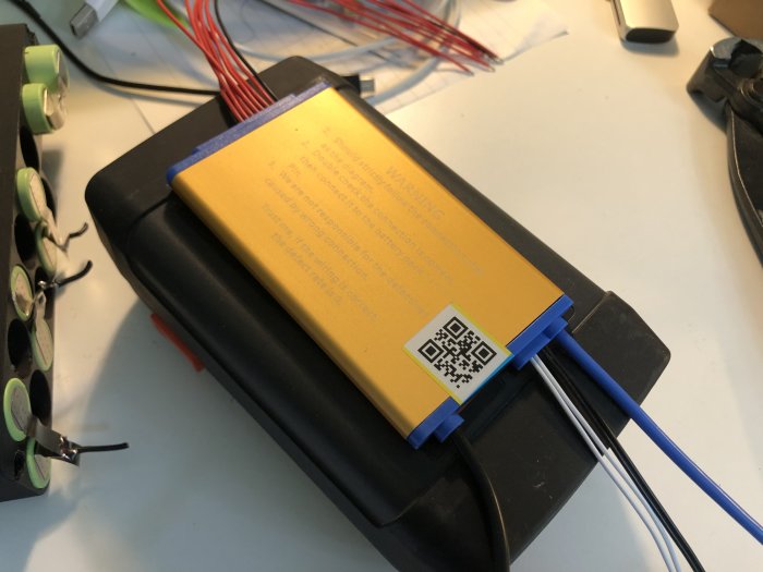 Ett öppnat batteri som visas upp med komponenter och kablar, under reparation eller modifiering.