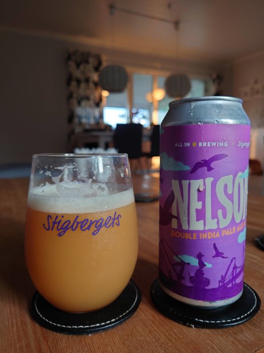 Ölglas med Stigbergets-logotyp och -ölburk märkt "All In Brewing & Stigbergets Nelson Double India Pale Ale".
