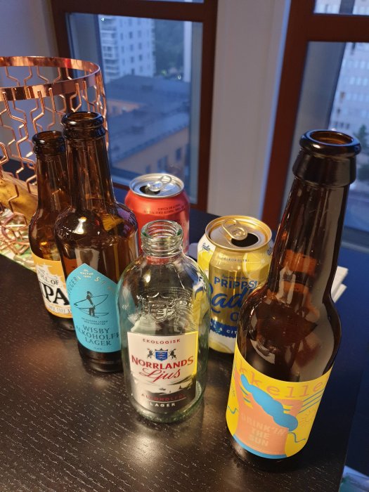 Flertalet ölflaskor och burkar på ett bord, inklusive en Norrlands Ljus alkoholfri lager och en Mikkeller Drinking in the Sun.